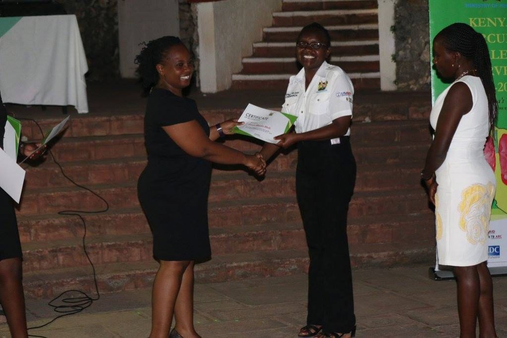 The Deputy Head of Program, NTLD-P, Dr. Maureen Kamene Presenting a certificate to Eunice Mailu who was a team lead of one of the data collection teams
